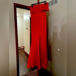 Red dress off the shoulder with slit up one side.